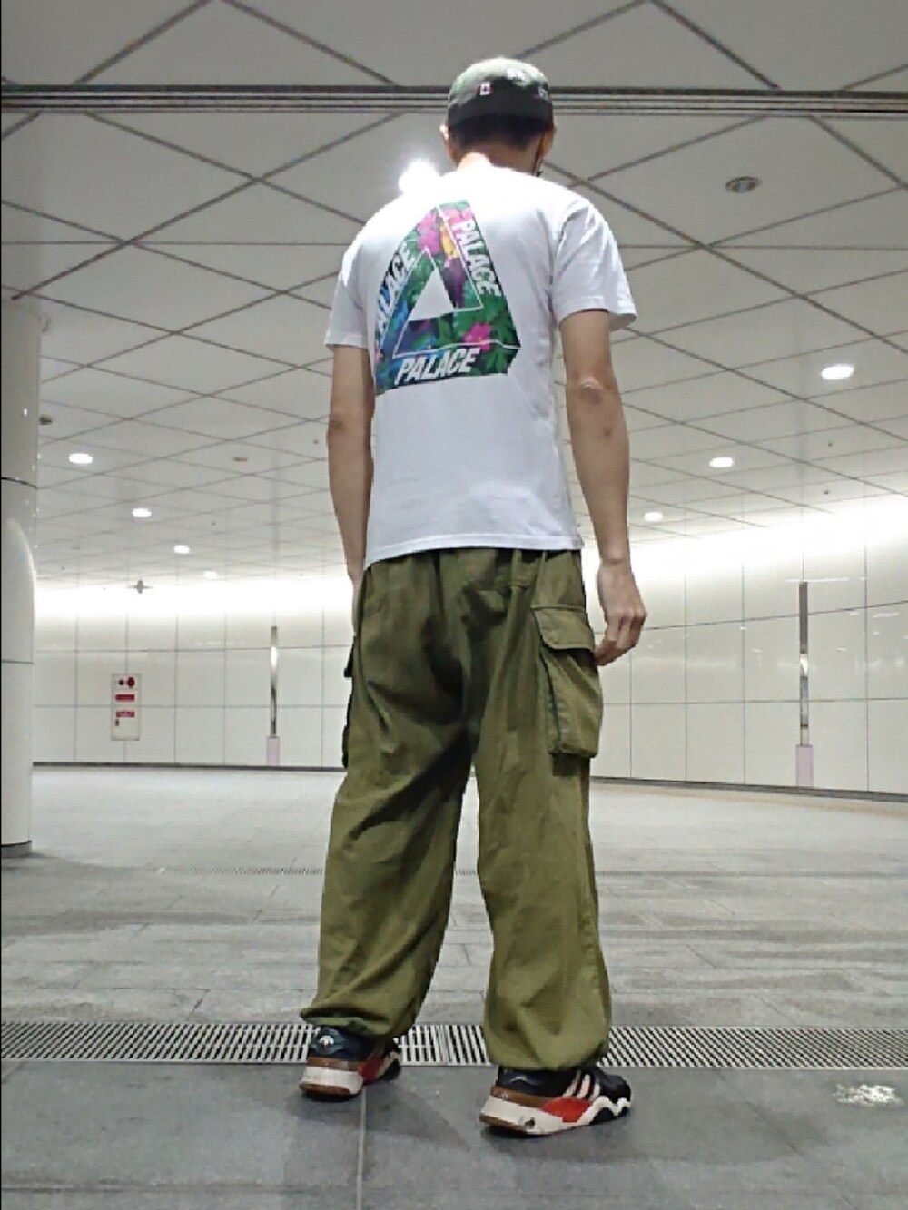 ホワイト系のTシャツ/カットソー、グリーン系のカーゴパンツ、ブラック系のスニーカーを着用したメンズの秋コーディネートの2枚目の写真