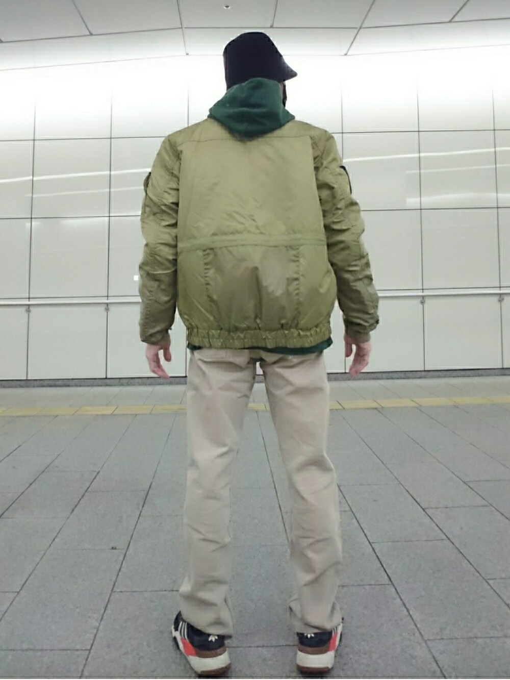 ベージュ系のMA-1、ベージュ系のデニムパンツ、ブラック系のスニーカーを着用したメンズの冬コーディネートの2枚目の写真