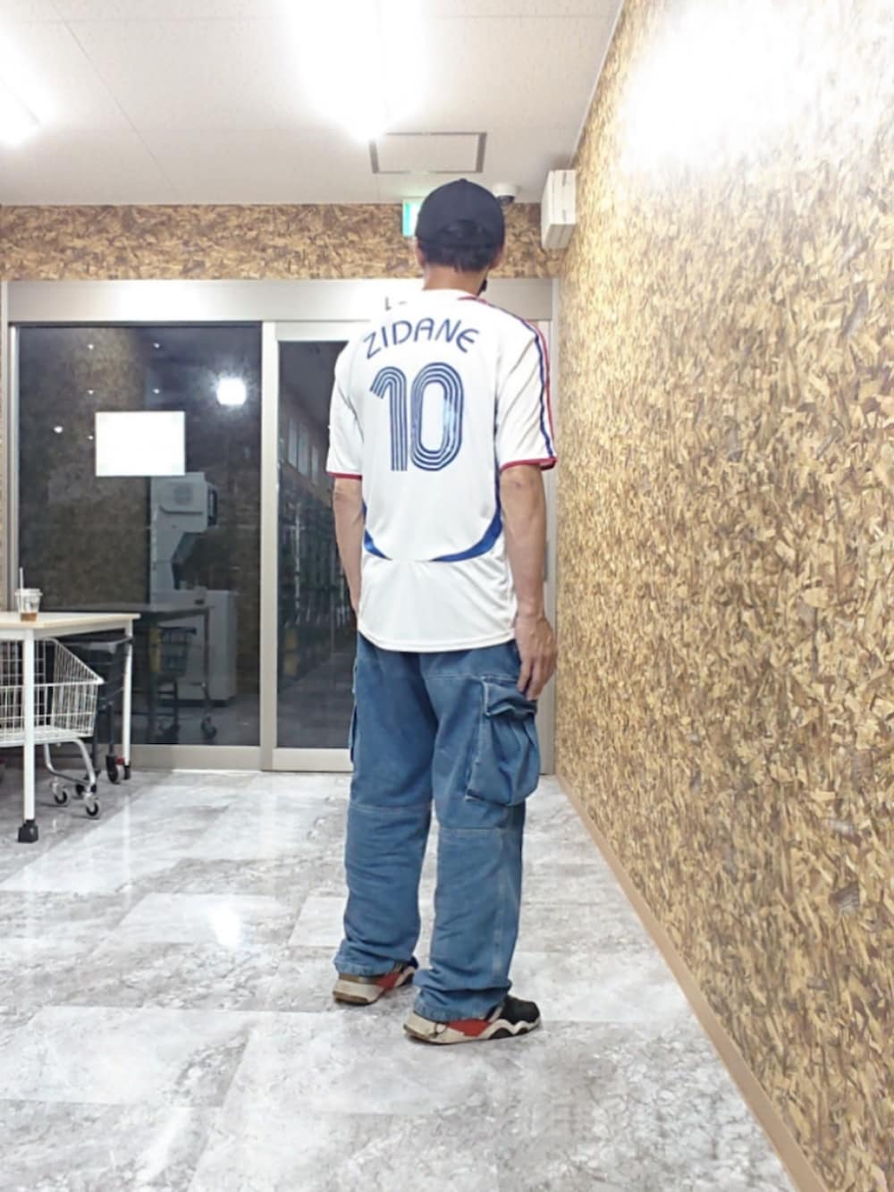 ホワイト系のTシャツ/カットソー、ブルー系のカーゴパンツ、ブラック系のスニーカーを着用したメンズの夏コーディネートの2枚目の写真