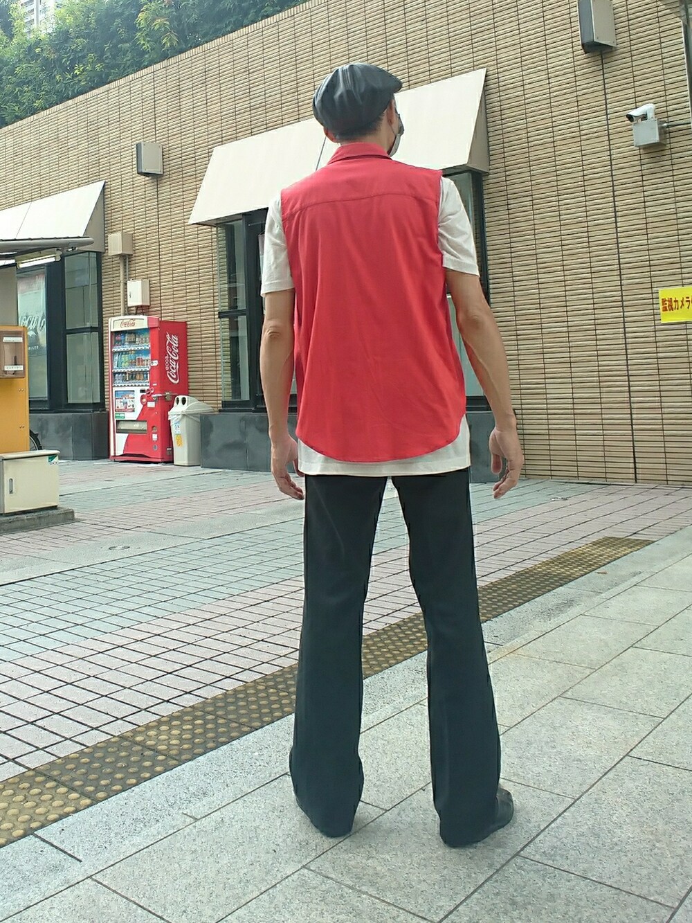 レッド系のベスト、ホワイト系のTシャツ/カットソー、ブラック系のスラックスを着用したメンズの夏コーディネートの2枚目の写真