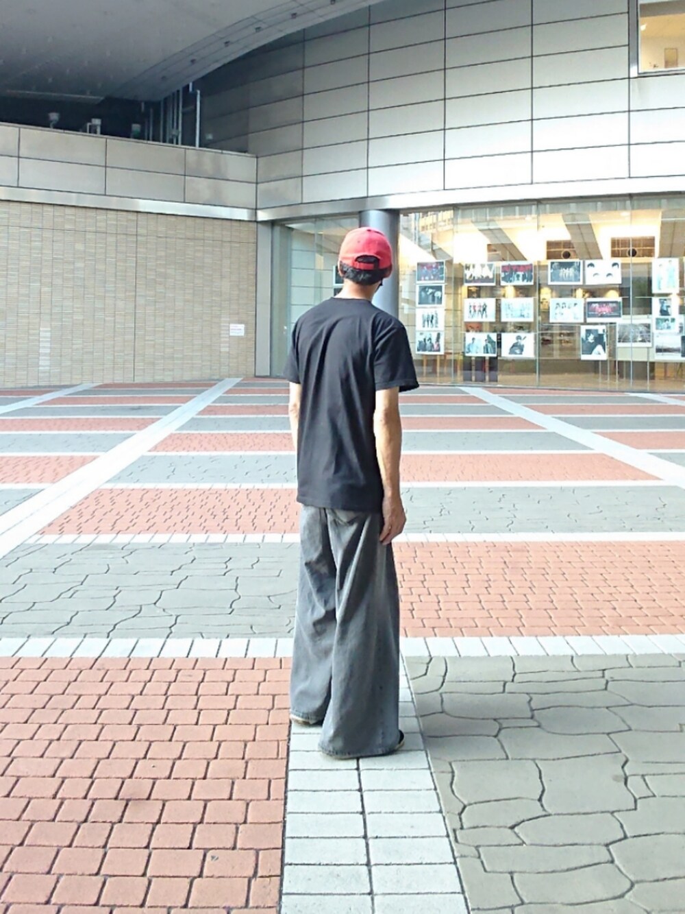 グレー系のデニムパンツ、ブラック系のTシャツ/カットソー、ブラック系のスニーカーを着用したメンズの夏コーディネートの2枚目の写真