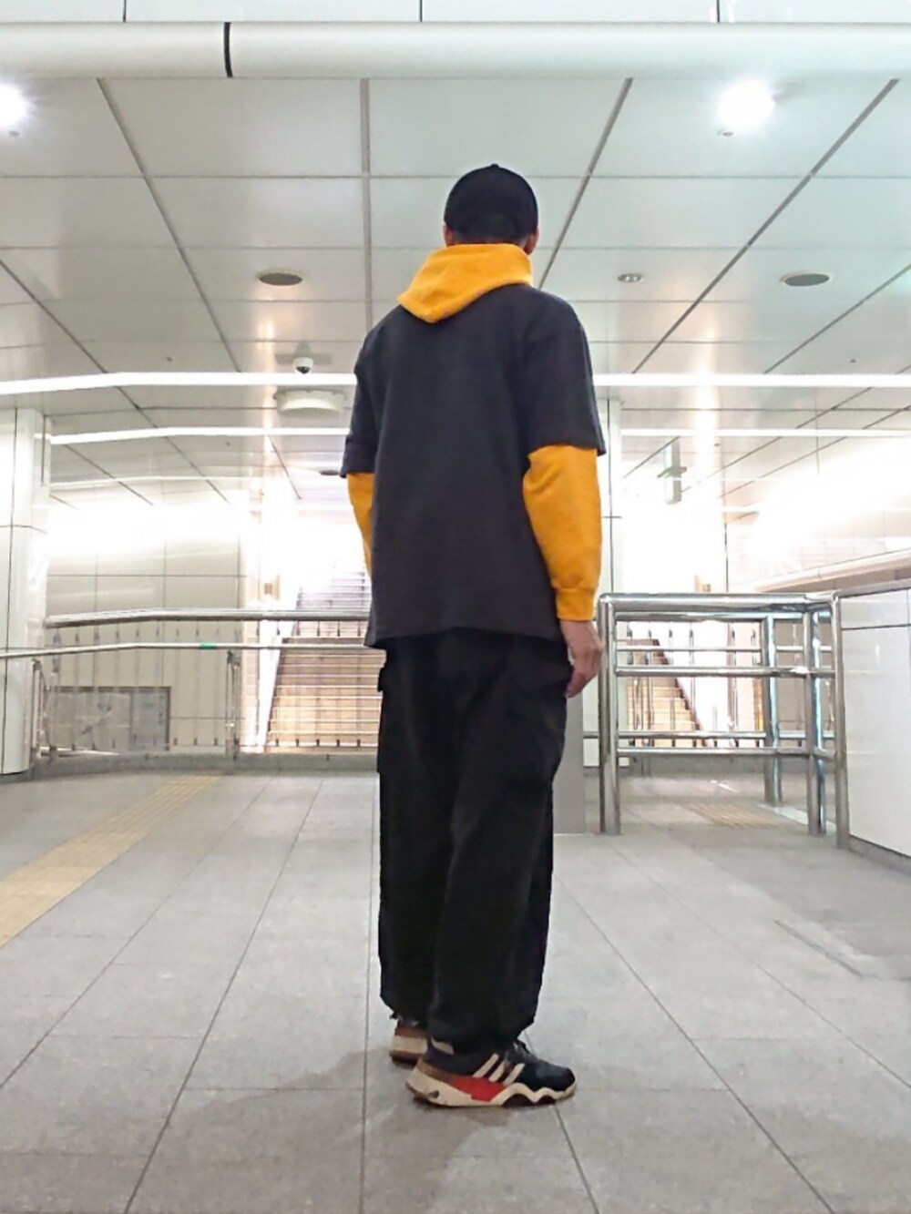 ブラック系のTシャツ/カットソー、ブラック系のカーゴパンツ、ブラック系のスニーカーを着用したメンズの春コーディネートの2枚目の写真