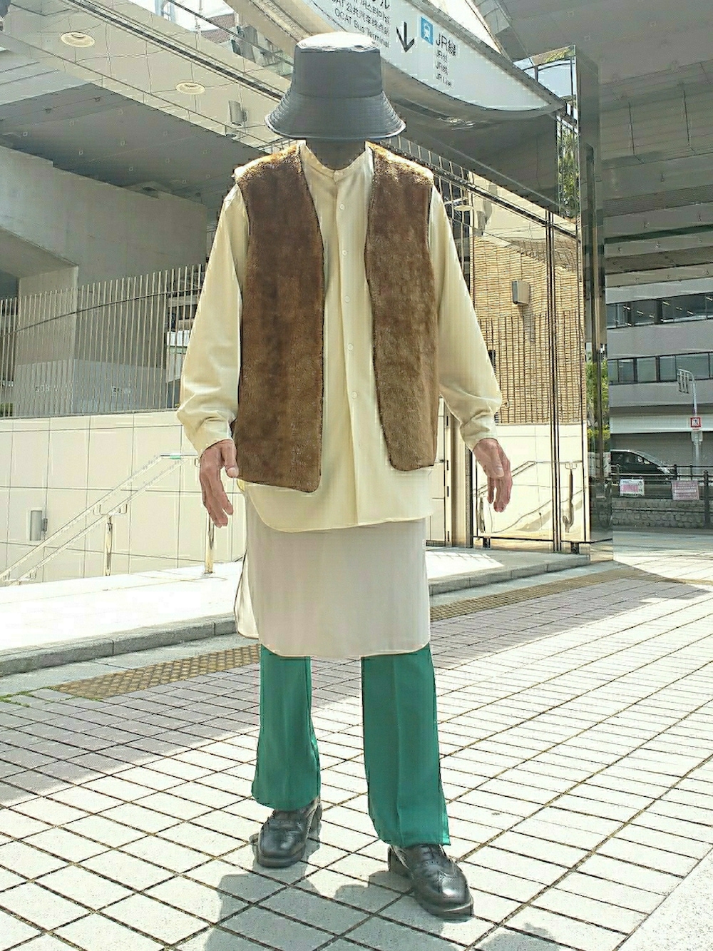 ブラウン系のベスト、グリーン系のスラックス、ブラック系のドレスシューズを着用したメンズの春コーディネートの2枚目の写真