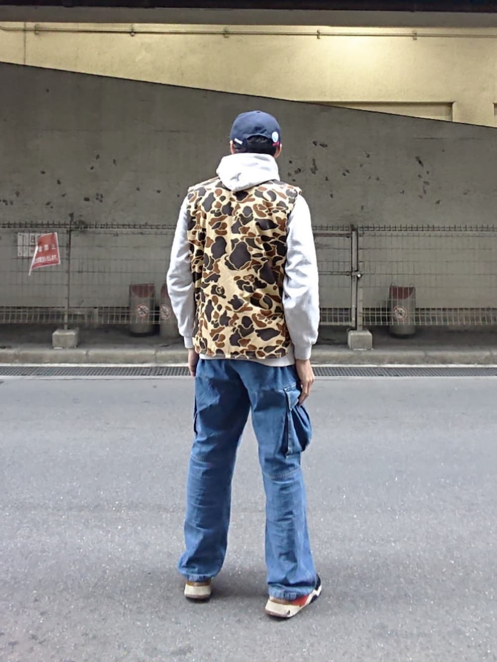 ブルー系のカーゴパンツ、ブラック系のスニーカー、その他のキャップを着用したメンズの春コーディネートの2枚目の写真