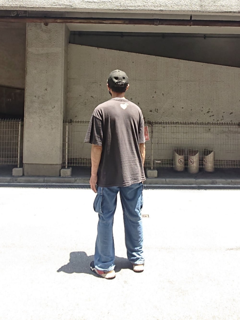 ブラック系のTシャツ/カットソー、ブルー系のカーゴパンツ、ブラック系のスニーカーを着用したメンズの夏コーディネートの2枚目の写真