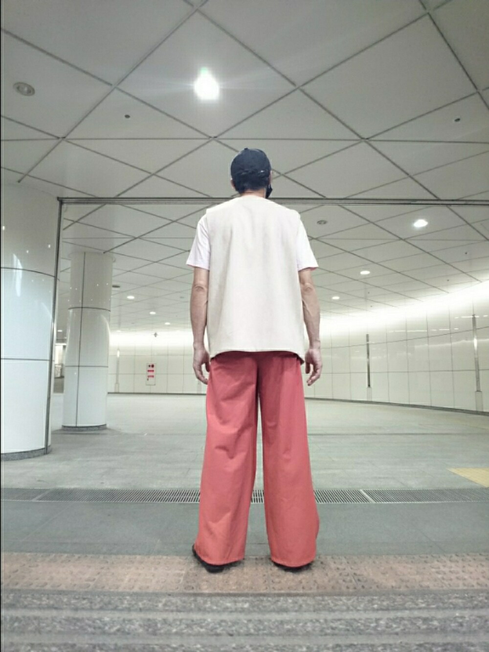 ピンク系のTシャツ/カットソー、ベージュ系のベスト、ブラウン系のその他パンツを着用したメンズの夏コーディネートの2枚目の写真