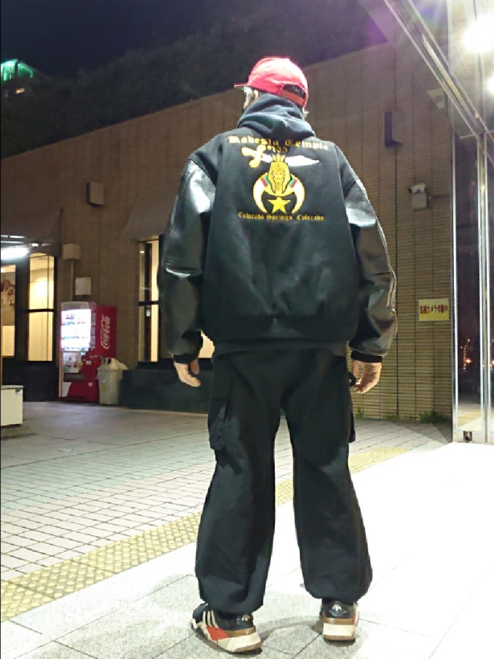 ブラック系のパーカー、ブラック系のスタジャン、ブラック系のカーゴパンツを着用したメンズの冬コーディネートの2枚目の写真