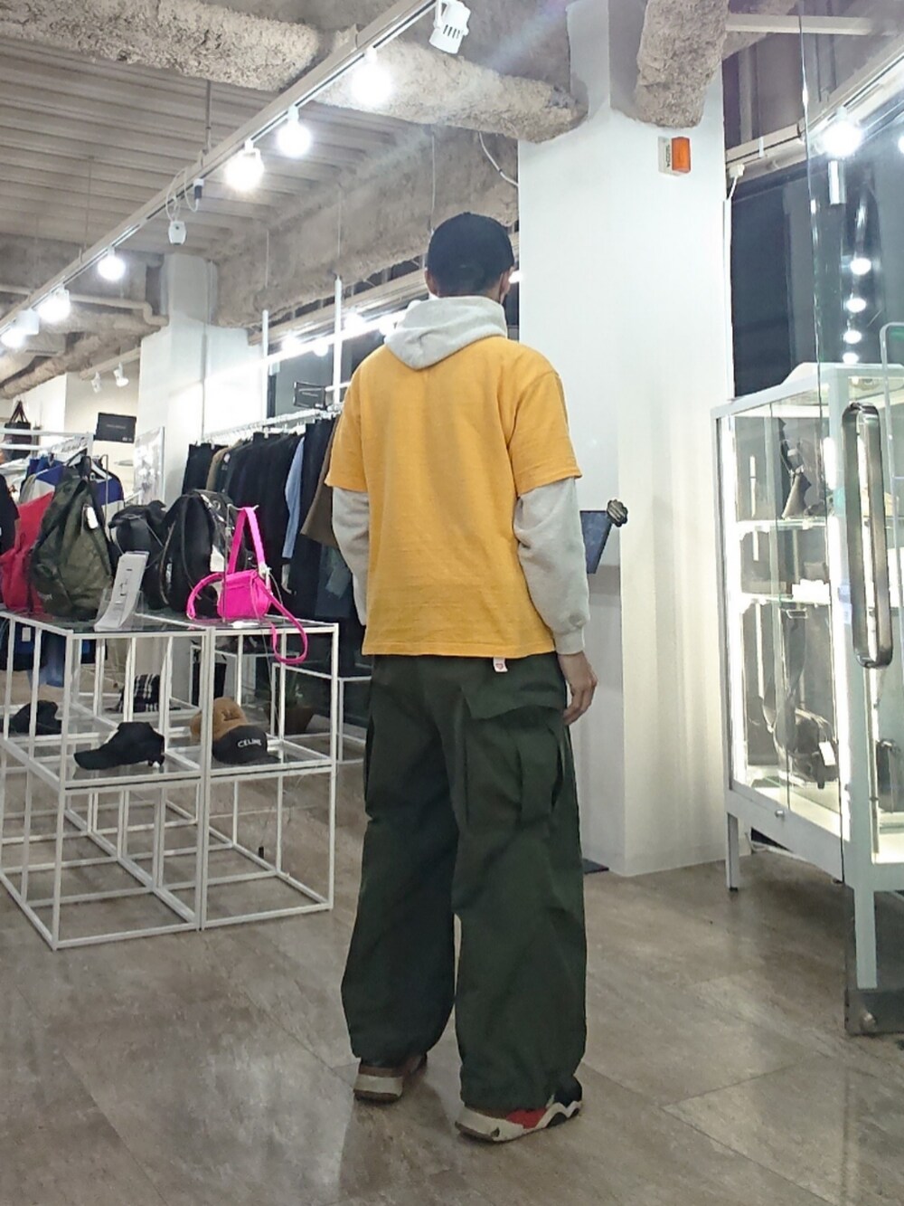 イエロー系のTシャツ/カットソー、グリーン系のカーゴパンツ、ブラック系のスニーカーを着用したメンズの春コーディネートの2枚目の写真