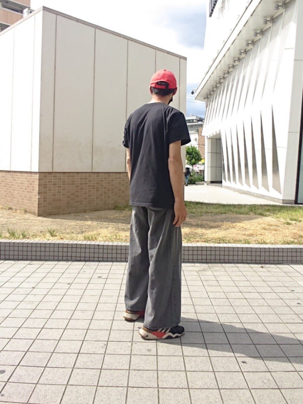 ブラック系のTシャツ/カットソー、グレー系のデニムパンツ、ブラック系のスニーカーを着用したメンズの夏コーディネートの2枚目の写真