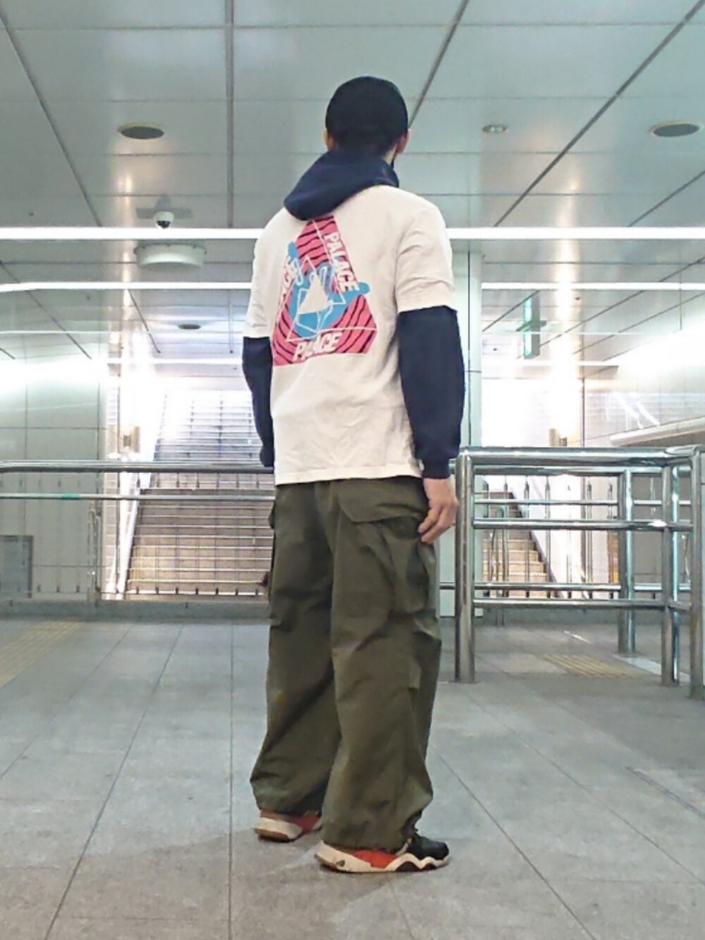 ホワイト系のTシャツ/カットソー、グリーン系のカーゴパンツ、ブラック系のスニーカーを着用したメンズの春コーディネートの2枚目の写真