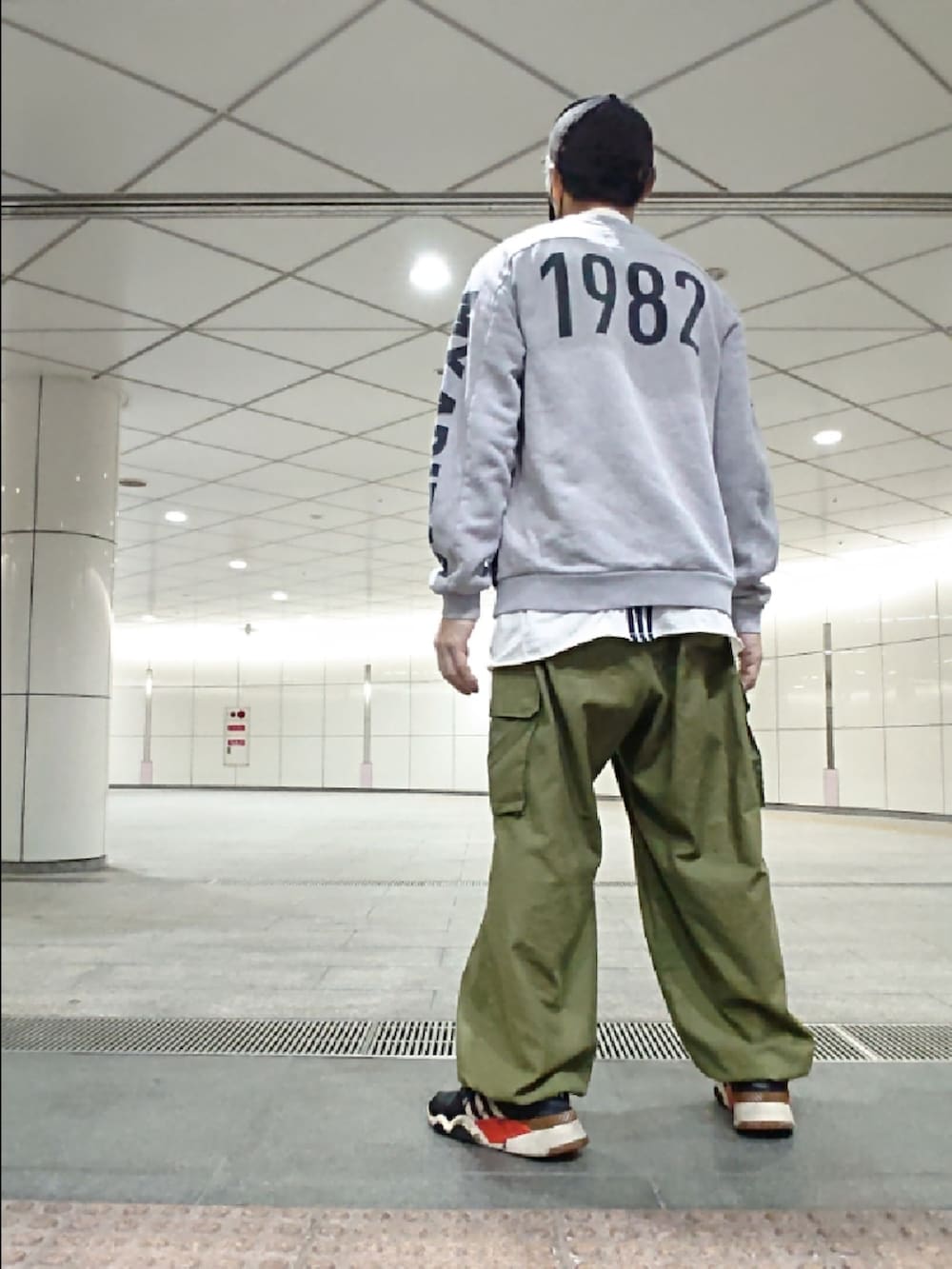 グレー系のスウェット、ホワイト系のTシャツ/カットソー、グリーン系のカーゴパンツを着用したメンズの秋コーディネートの2枚目の写真