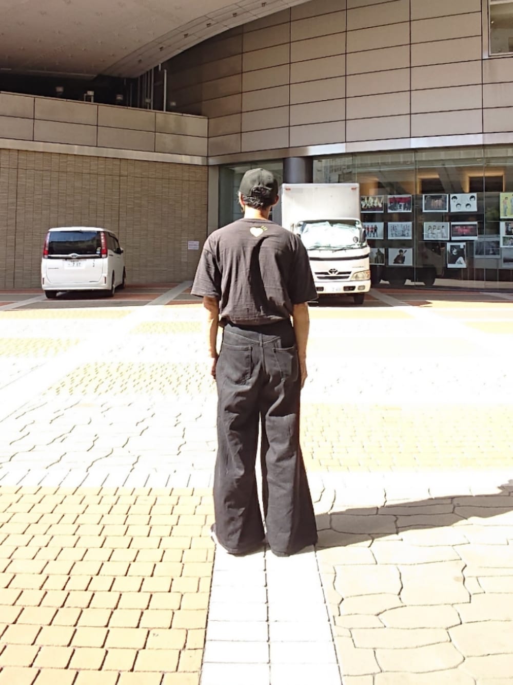 ブラック系のTシャツ/カットソー、ブラック系のデニムパンツ、ブラック系のスニーカーを着用したメンズの夏コーディネートの2枚目の写真