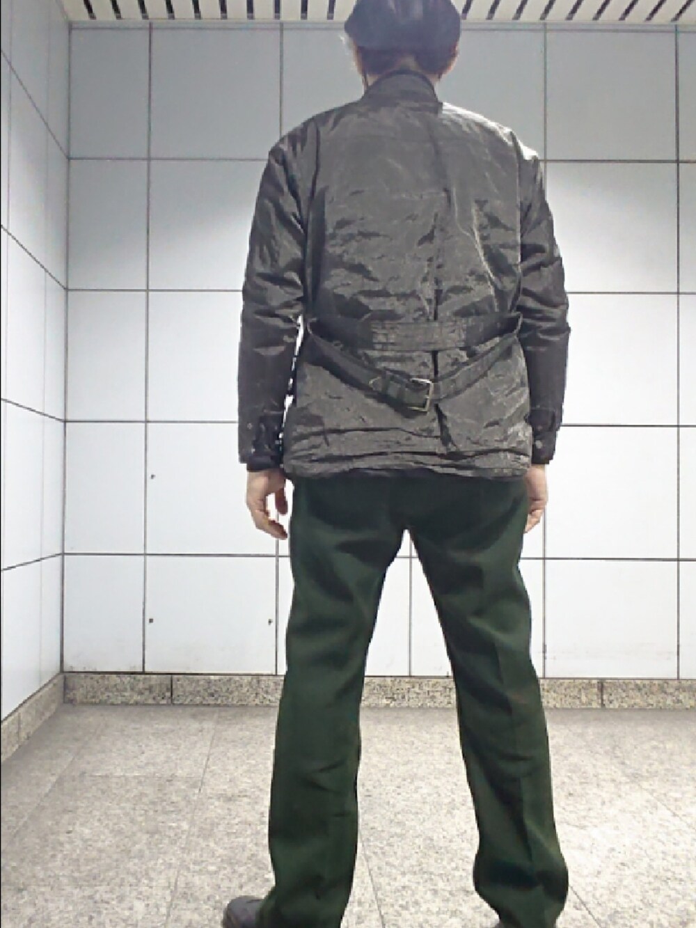 グレー系のテーラードジャケット、グリーン系のスラックス、ブラック系のドレスシューズを着用したメンズの春コーディネートの2枚目の写真