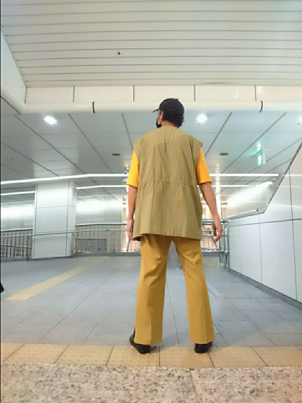 イエロー系のTシャツ/カットソー、グリーン系のベスト、イエロー系のその他パンツを着用したメンズの夏コーディネートの2枚目の写真