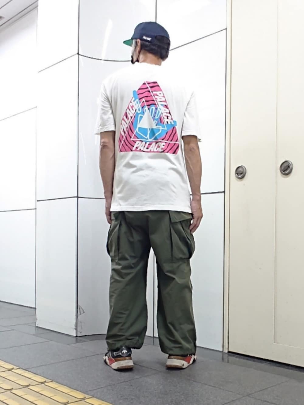 ホワイト系のTシャツ/カットソー、グリーン系のカーゴパンツ、ブラック系のスニーカーを着用したメンズの夏コーディネートの2枚目の写真