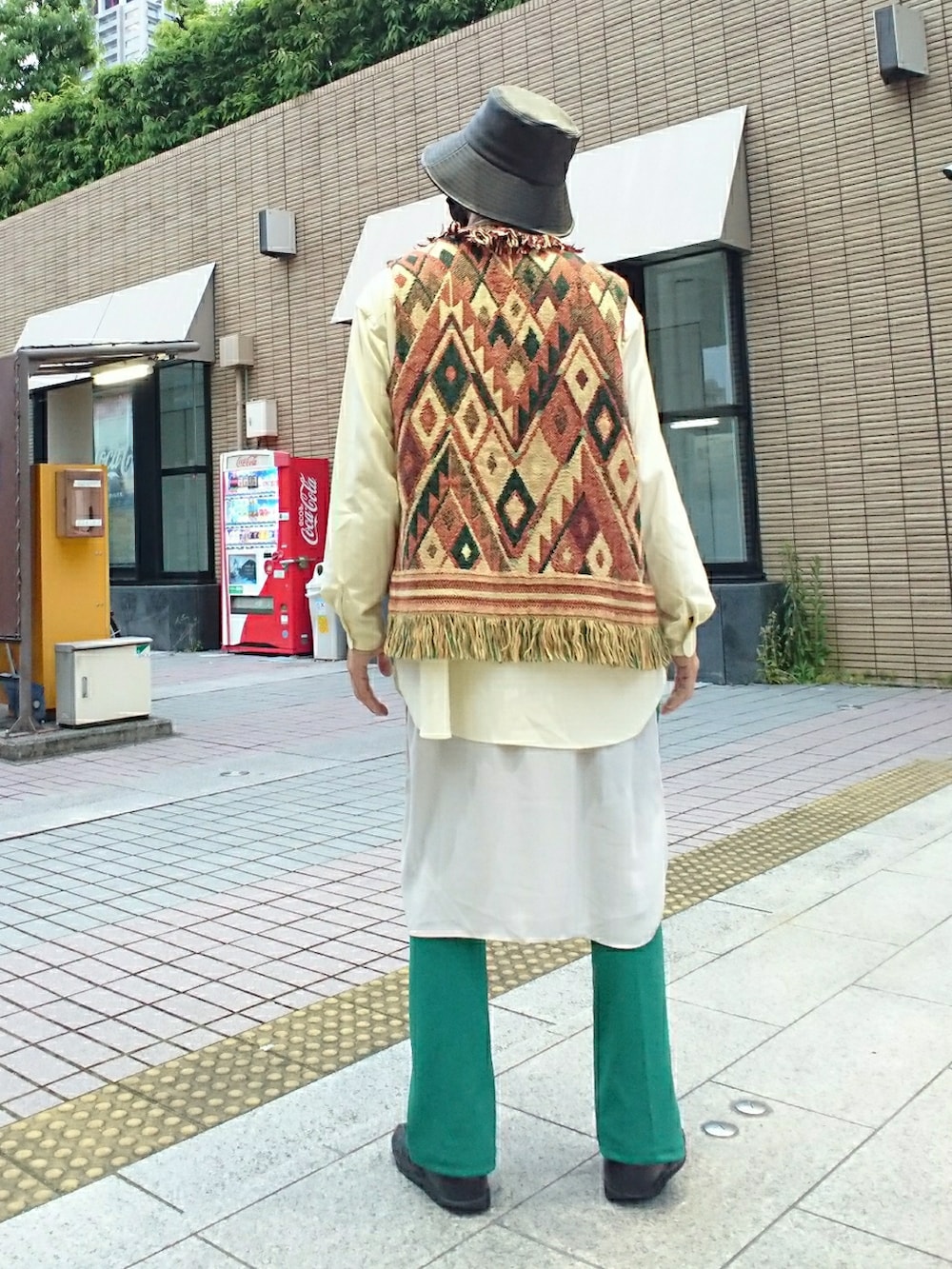 その他のベスト、グリーン系のスラックス、ブラック系のサンダルを着用したメンズの春コーディネートの2枚目の写真