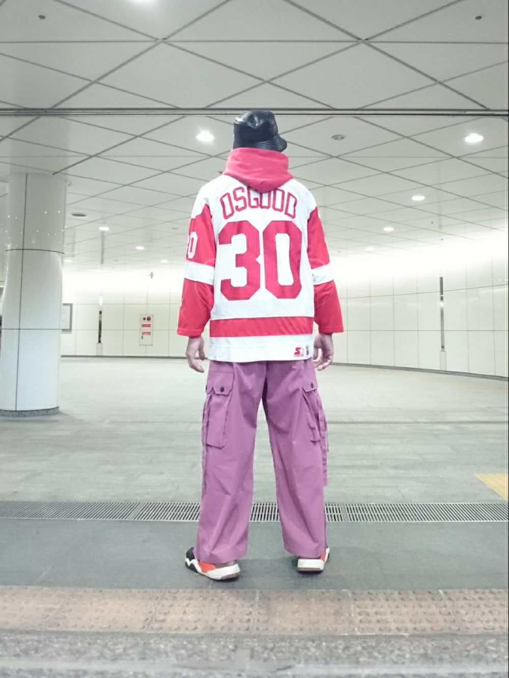 ホワイト系のトップス、ピンク系のカーゴパンツ、ブラック系のスニーカーを着用したメンズの春コーディネートの2枚目の写真