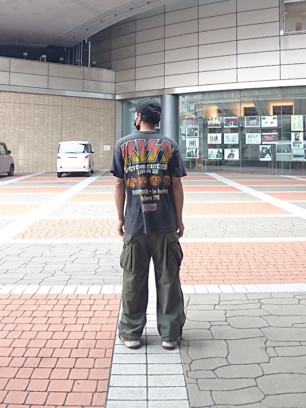 ブラック系のTシャツ/カットソー、グリーン系のカーゴパンツ、ブラック系のスニーカーを着用したメンズの夏コーディネートの2枚目の写真