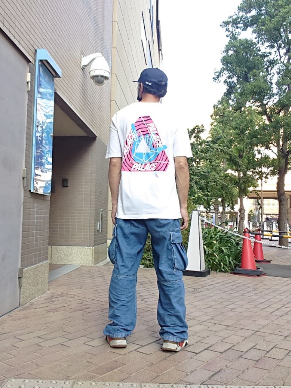 ホワイト系のTシャツ/カットソー、ブルー系のカーゴパンツ、ブラック系のスニーカーを着用したメンズの夏コーディネートの2枚目の写真