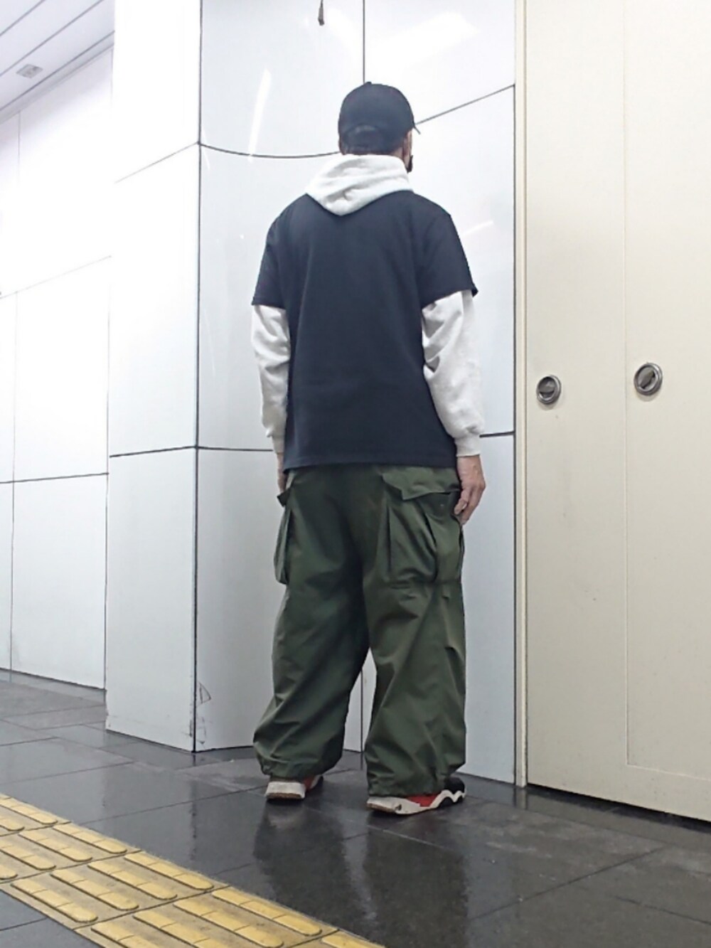 ブラック系のTシャツ/カットソー、グリーン系のカーゴパンツ、ブラック系のスニーカーを着用したメンズの夏コーディネートの2枚目の写真