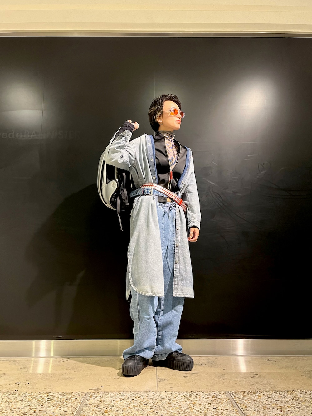 ブラック系のスニーカー、ブルー系のデニムパンツ、ブルー系のワンピース/ドレスを着用したレディースの秋コーディネートの2枚目の写真