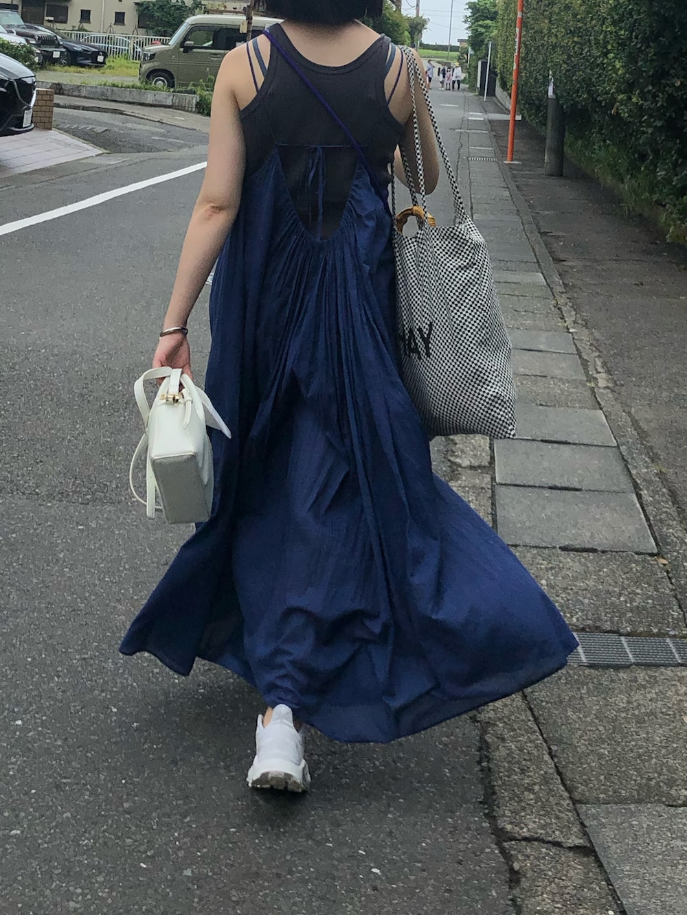 ブルー系のワンピース、ホワイト系のスニーカー、ホワイト系のショルダーバッグを着用したレディースの夏コーディネートの2枚目の写真