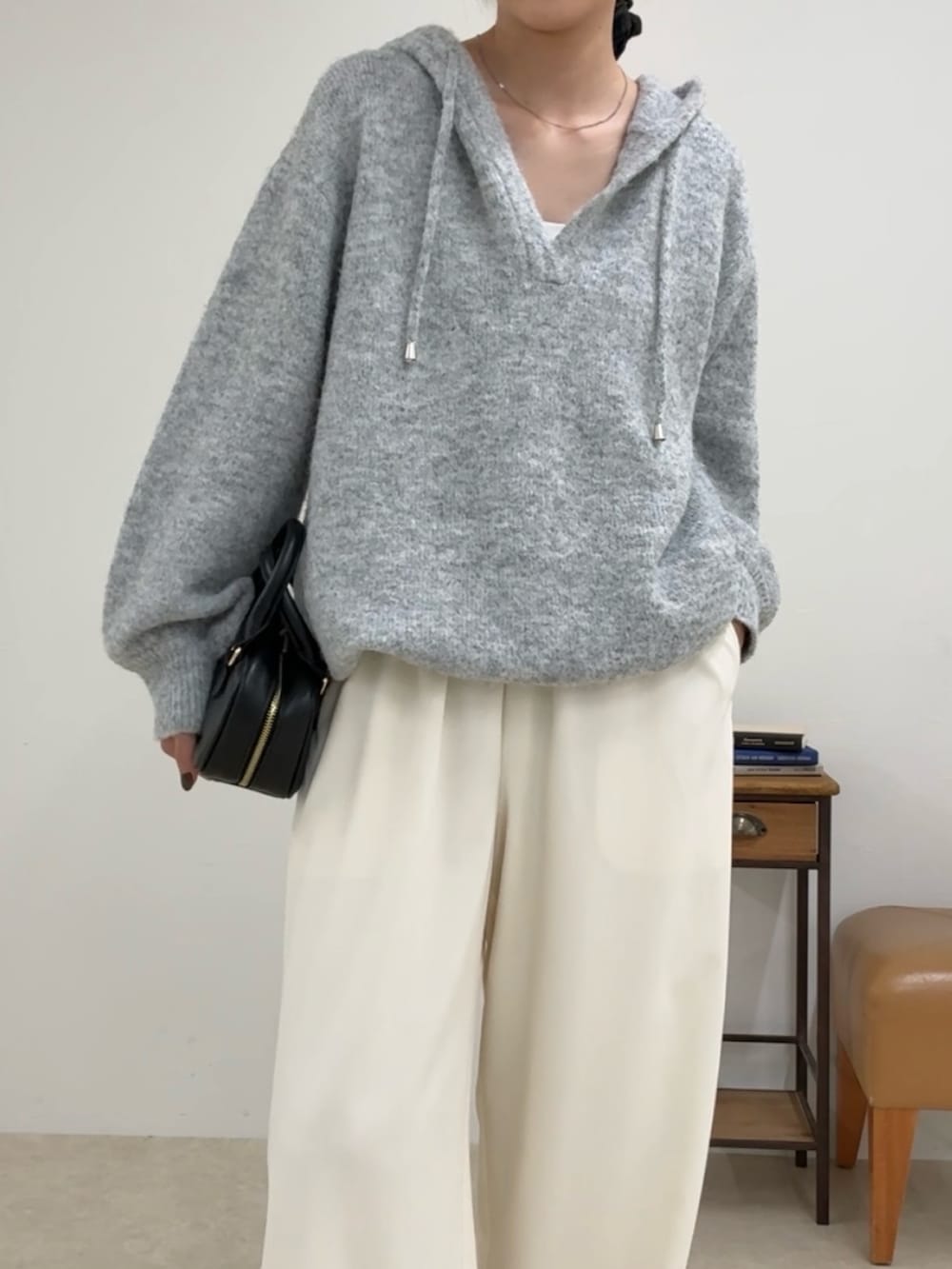 グレー系のニット/セーター、ホワイト系のその他パンツ、ブラック系のショルダーバッグを着用したレディースの夏コーディネートの4枚目の写真