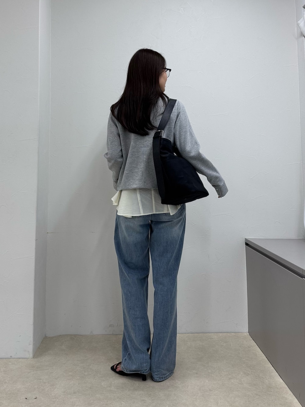 グレー系のカーディガン/ボレロ、ブルー系のデニムパンツ、ホワイト系のシャツ/ブラウスを着用したレディースの春コーディネートの4枚目の写真