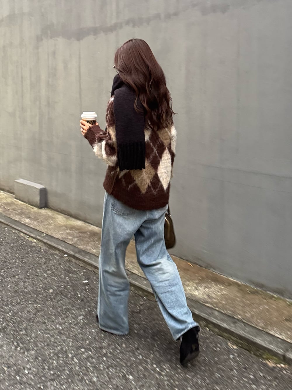 ブラウン系のニット/セーター、グリーン系のショルダーバッグ、ブルー系のデニムパンツを着用したレディースの秋コーディネートの2枚目の写真