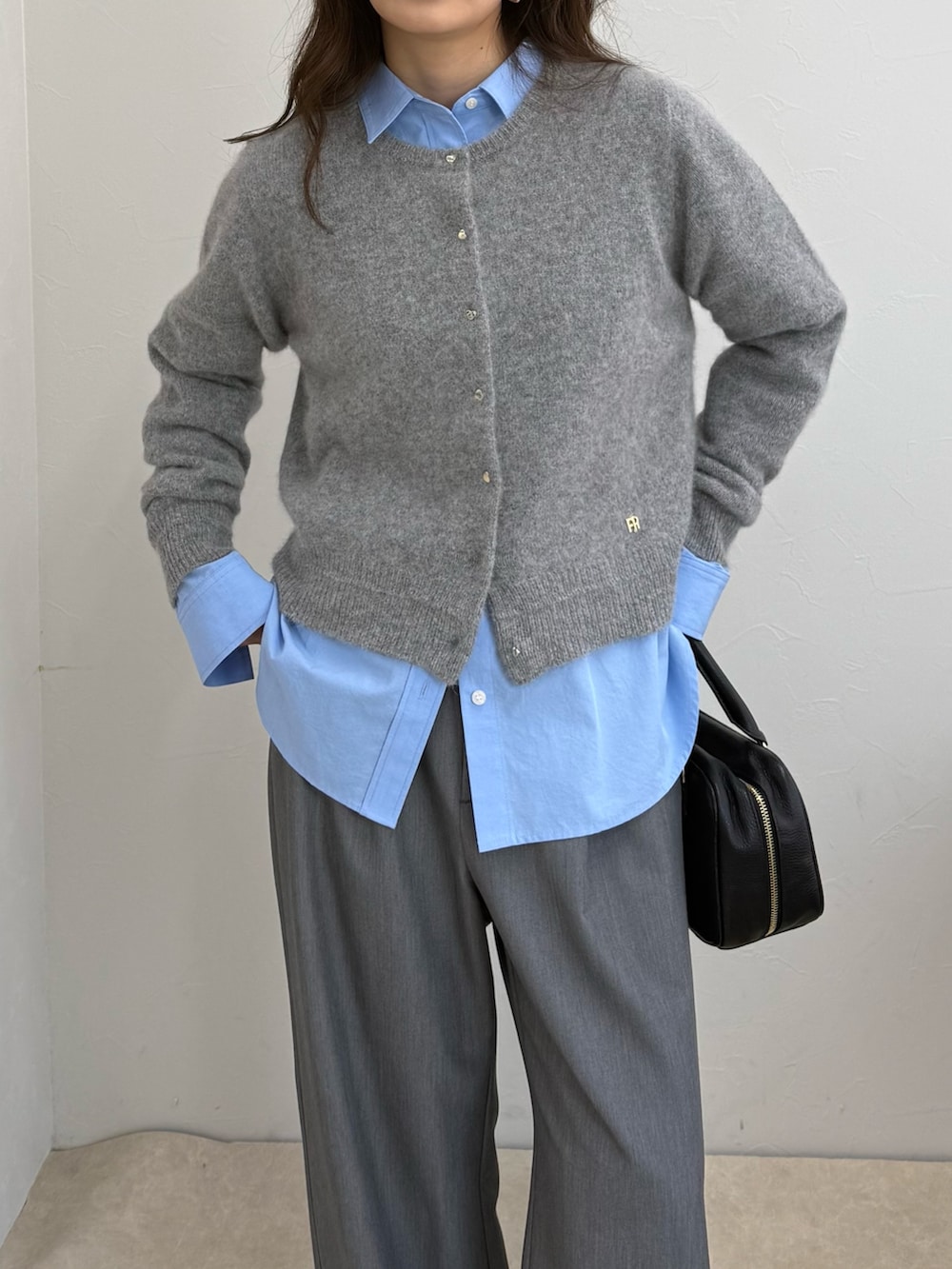 グレー系のカーディガン/ボレロ、ブルー系のシャツ/ブラウス、ブラック系のボストンバッグを着用したレディースの秋コーディネートの6枚目の写真