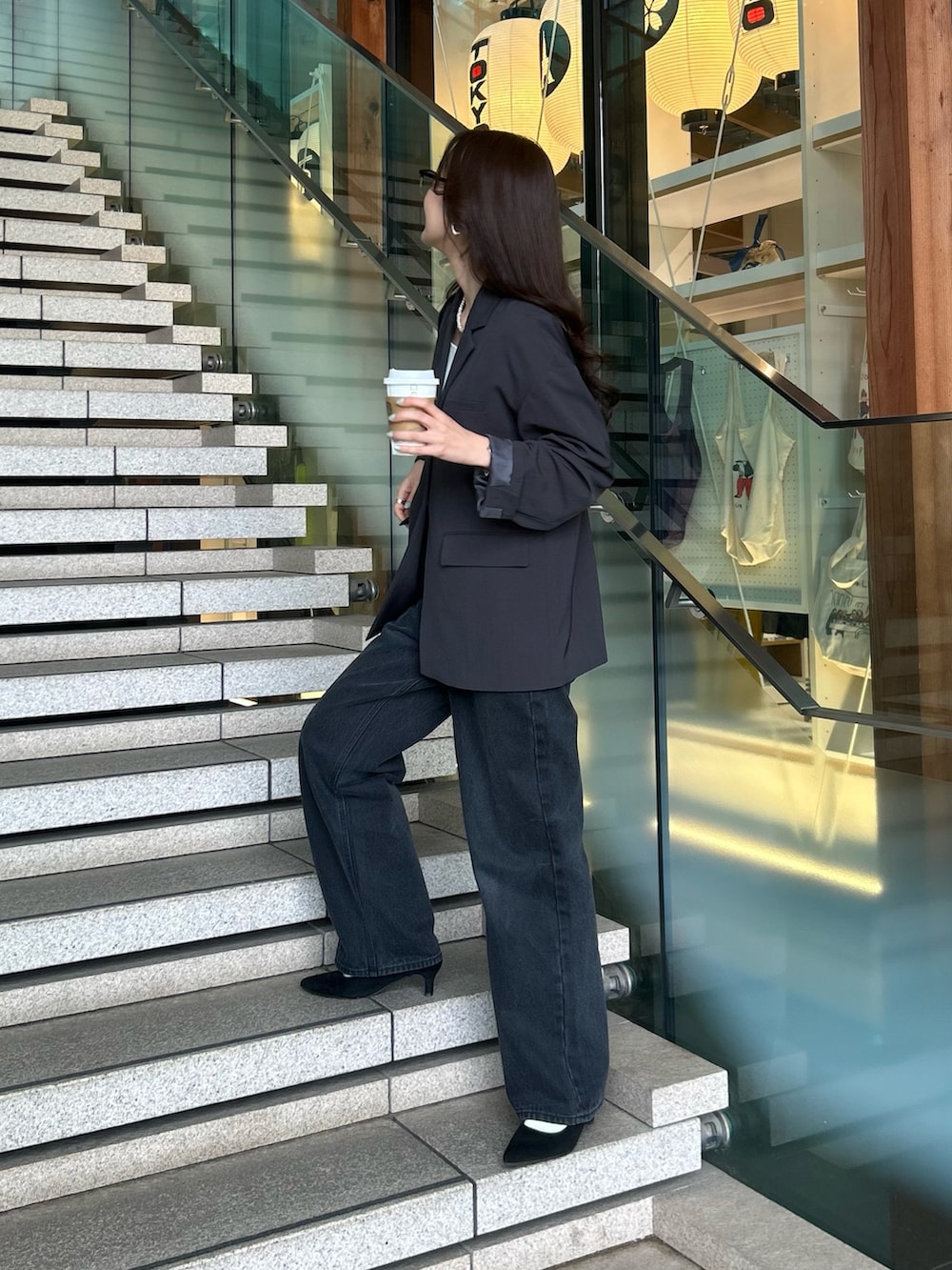 グレー系のテーラードジャケット、ブラック系のデニムパンツを着用したレディースの冬コーディネートの2枚目の写真