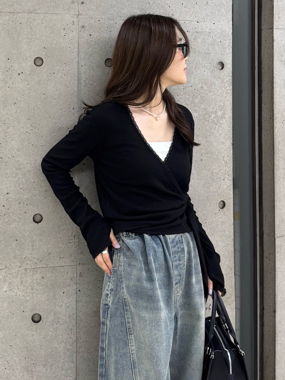 ブラック系のTシャツ/カットソー、ブラック系のボストンバッグを着用したレディースの秋コーディネートの7枚目の写真