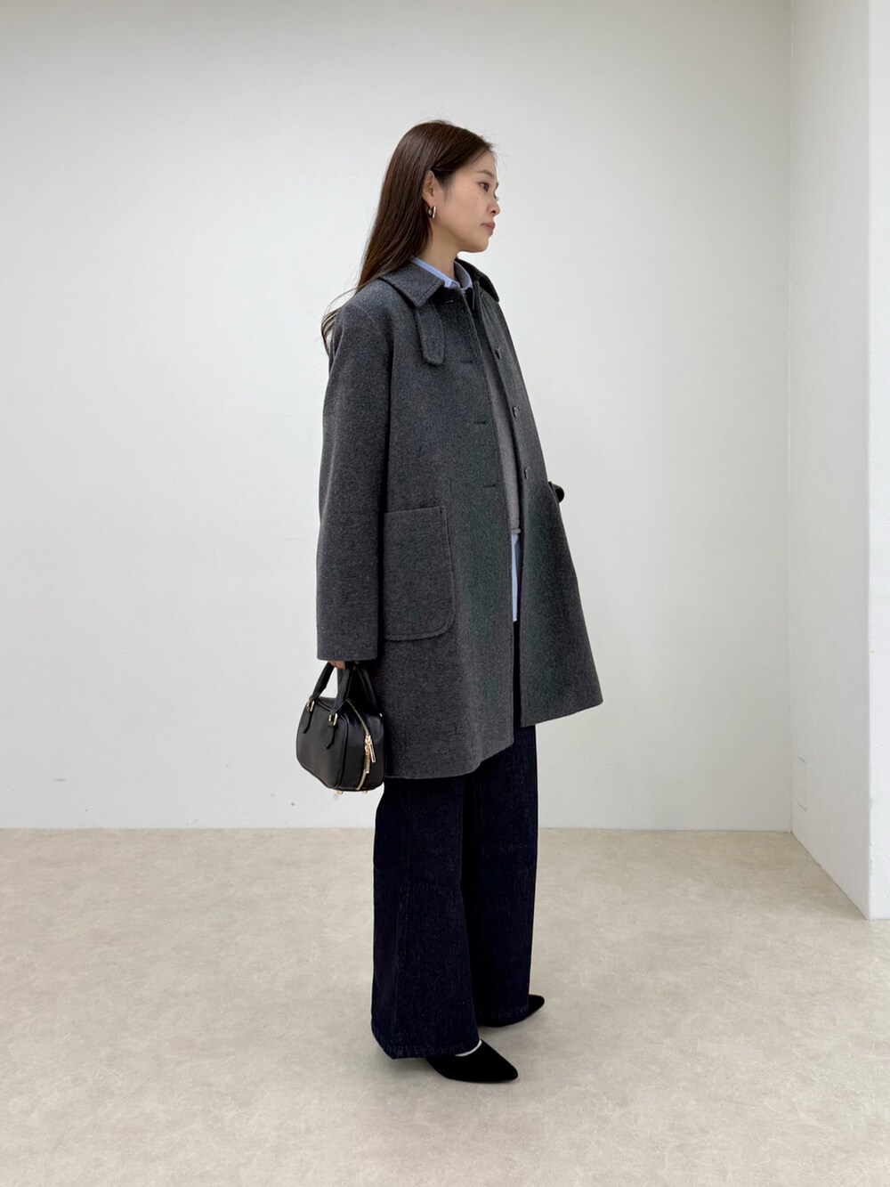 グレー系のダッフルコート、ブルー系のデニムパンツ、グレー系のニット/セーターを着用したレディースの秋コーディネートの2枚目の写真