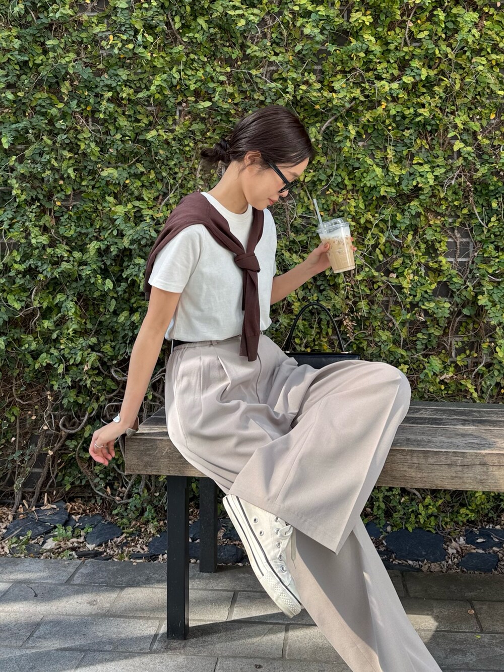 ブラウン系のカーディガン/ボレロ、ホワイト系のTシャツ/カットソー、ベージュ系のその他パンツを着用したレディースの春コーディネートの2枚目の写真