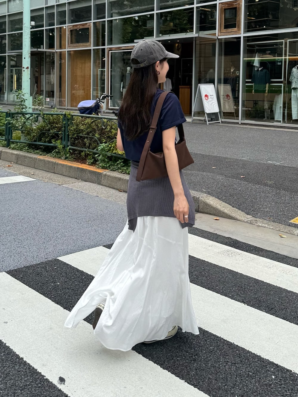 ブルー系のTシャツ/カットソー、ホワイト系のスカート、グレー系のキャップを着用したレディースの夏コーディネートの6枚目の写真