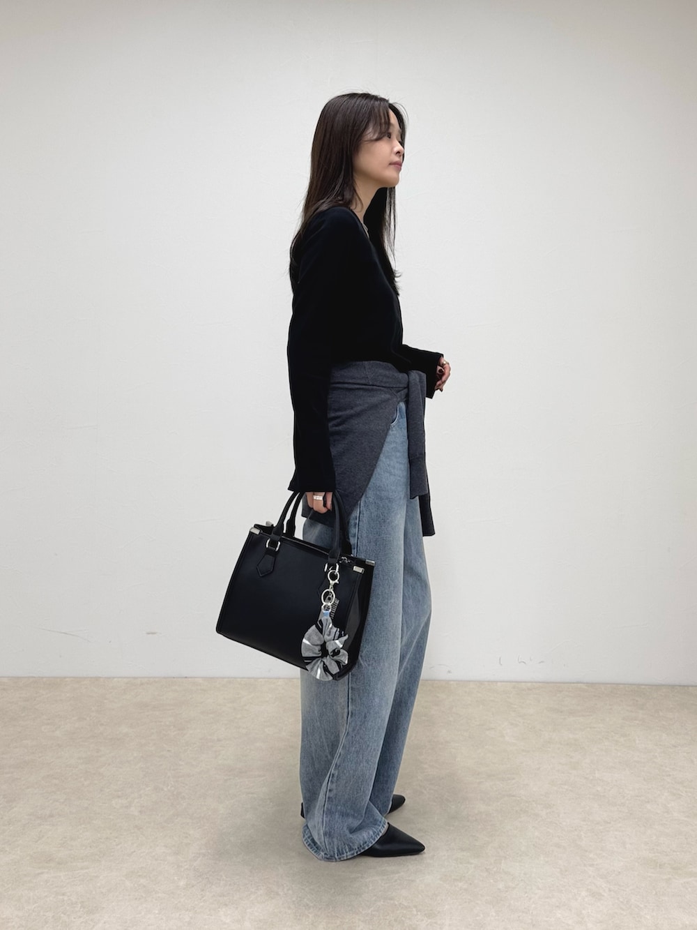 ブラック系のTシャツ/カットソー、ブルー系のデニムパンツ、ブラック系のボストンバッグを着用したレディースの秋コーディネートの3枚目の写真