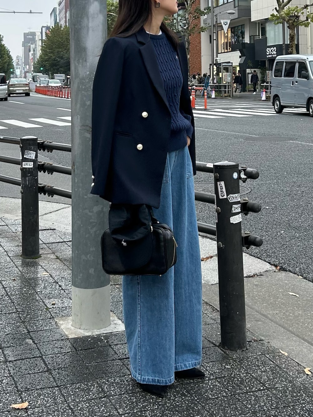 ブルー系のニット/セーター、ブルー系のテーラードジャケット、ブラック系のハンドバッグを着用したレディースの秋コーディネートの2枚目の写真