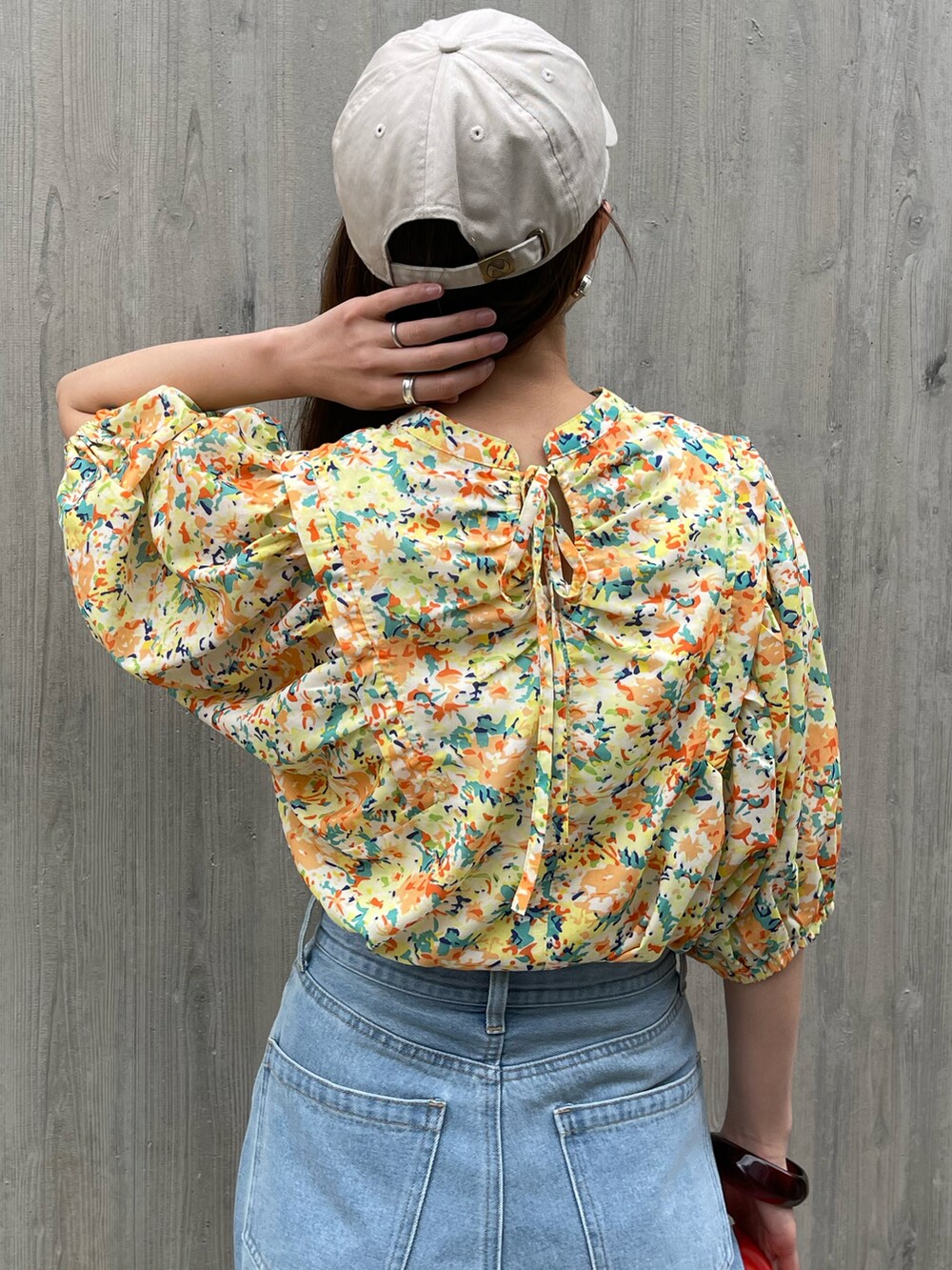 ブルー系のデニムパンツ、イエロー系のシャツ/ブラウス、オレンジ系のショルダーバッグを着用したレディースの春コーディネートの4枚目の写真