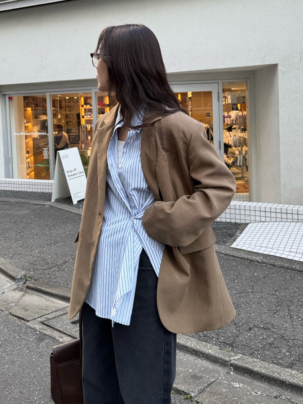 ブラウン系のテーラードジャケット、ブルー系のシャツ/ブラウス、ブラック系のデニムパンツを着用したレディースの冬コーディネートの2枚目の写真