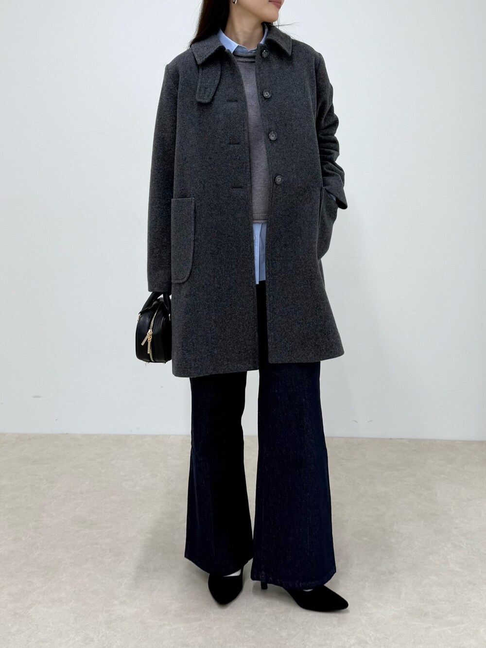 グレー系のダッフルコート、ブルー系のデニムパンツ、グレー系のニット/セーターを着用したレディースの秋コーディネートの5枚目の写真