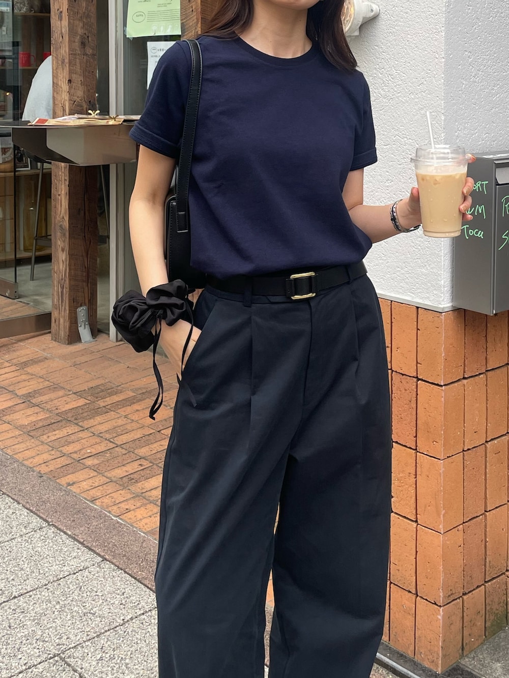 ブルー系のTシャツ/カットソー、ブルー系のチノパンツ、ブラック系のショルダーバッグを着用したレディースの春コーディネートの3枚目の写真