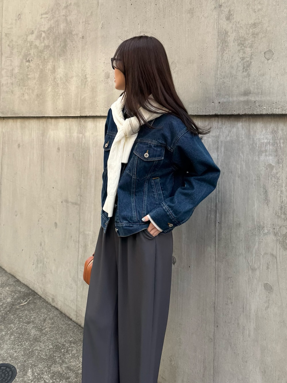 ブルー系のデニムジャケット、グレー系のその他パンツ、ホワイト系のカーディガン/ボレロを着用したレディースの春コーディネートの4枚目の写真