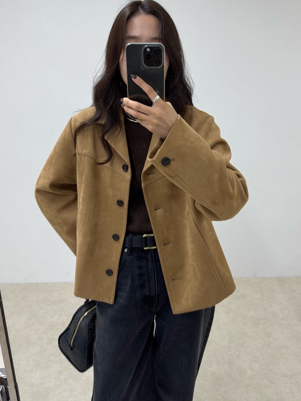 ブラック系のデニムパンツ、ベージュ系のダウンジャケット/コート、ブラウン系のニット/セーターを着用したレディースの秋コーディネートの3枚目の写真