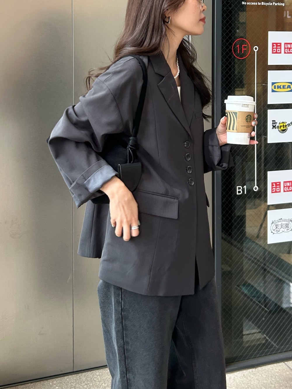 グレー系のテーラードジャケット、ブラック系のデニムパンツを着用したレディースの冬コーディネートの4枚目の写真