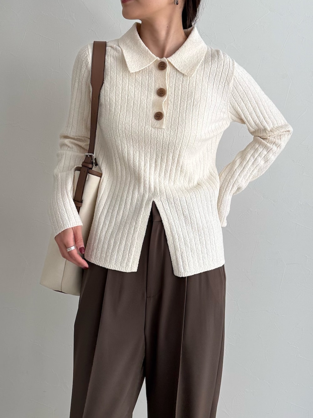 ホワイト系のニット/セーター、ブラウン系のスラックス、ホワイト系のショルダーバッグを着用したレディースの冬コーディネートの4枚目の写真