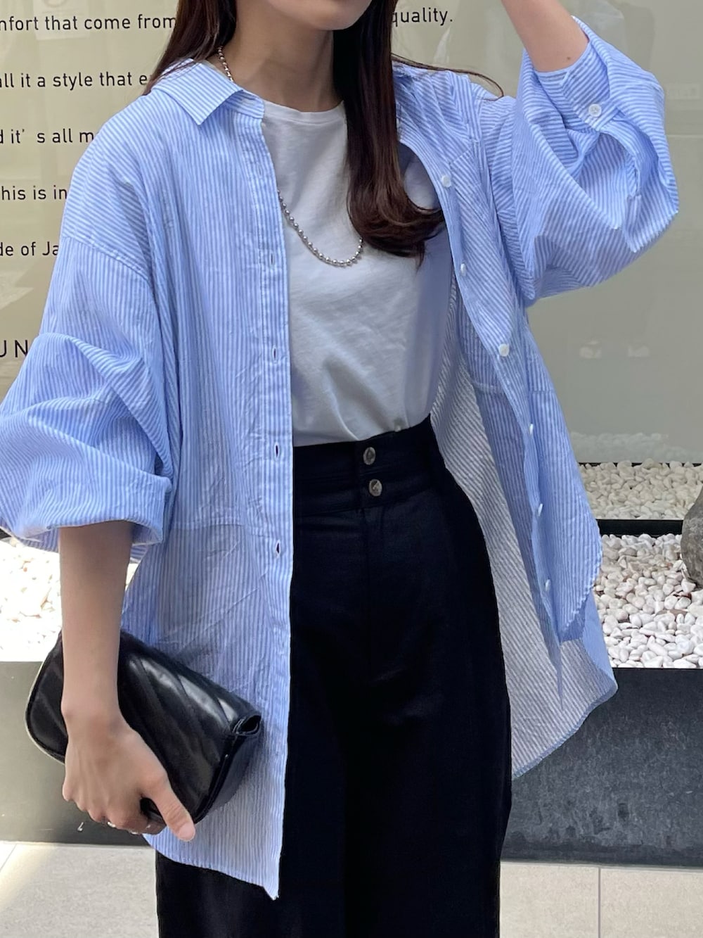 ブルー系のシャツ/ブラウス、グレー系のTシャツ/カットソー、ブラック系のスラックスを着用したレディースの春コーディネートの2枚目の写真