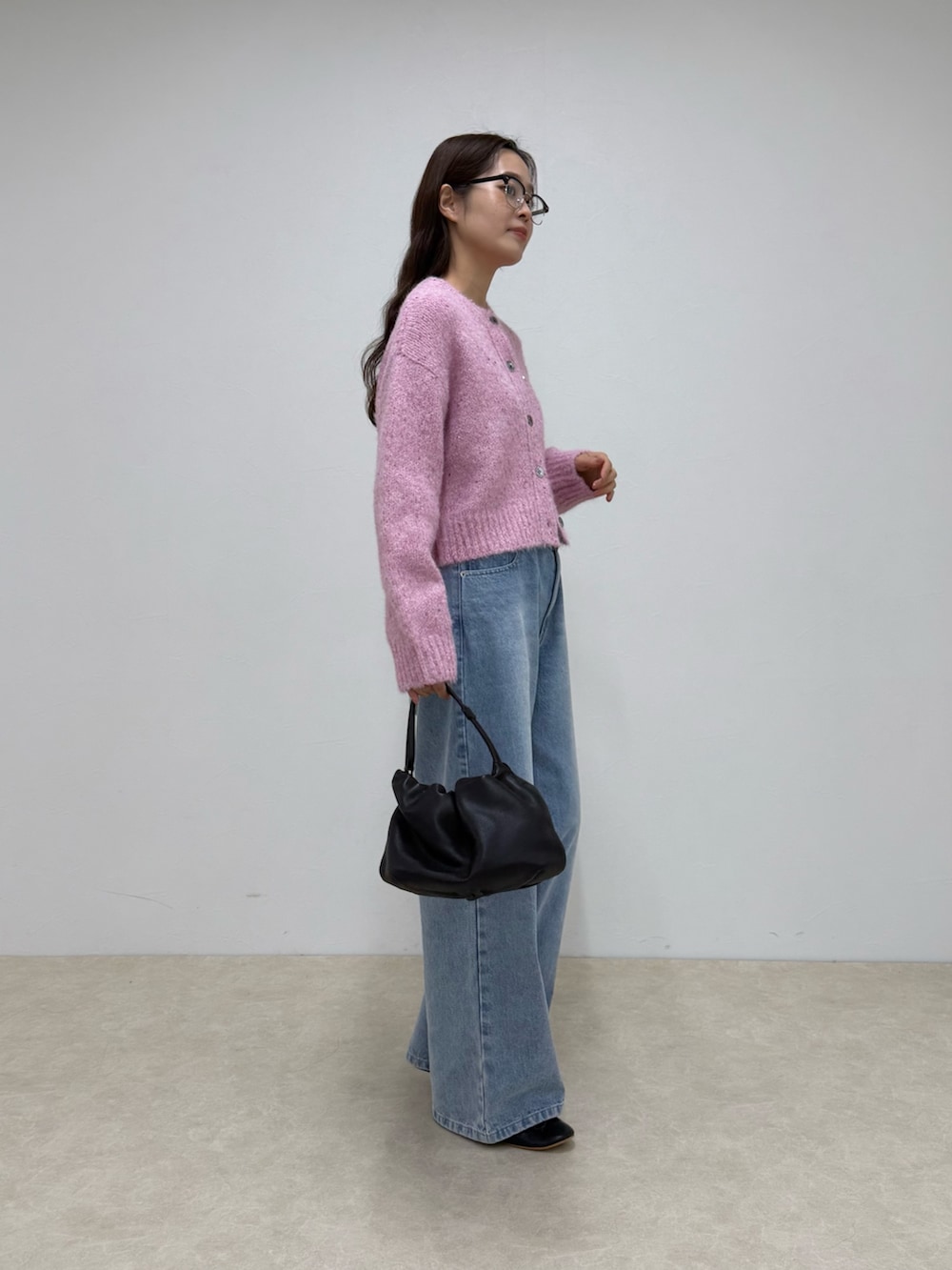 ピンク系のカーディガン/ボレロ、ブルー系のデニムパンツを着用したレディースの秋コーディネートの2枚目の写真