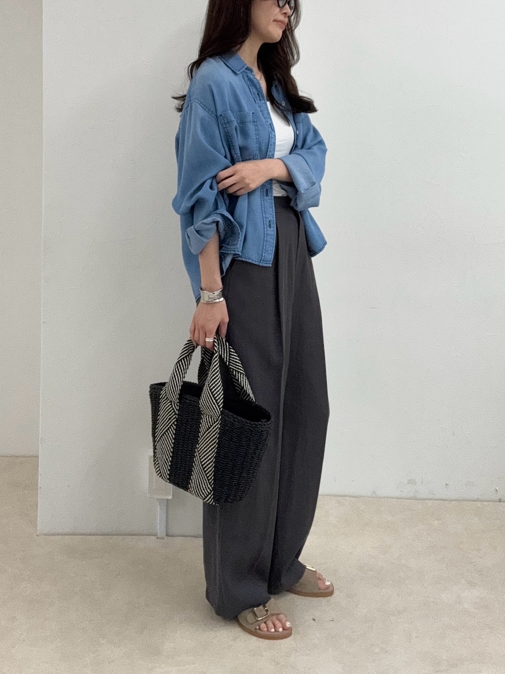 ブルー系のシャツ/ブラウス、グレー系のスラックスを着用したレディースの春コーディネートの2枚目の写真