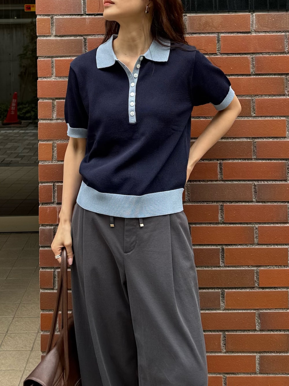 ブルー系のニット/セーター、グレー系のその他パンツ、ブラウン系のショルダーバッグを着用したレディースの春コーディネートの5枚目の写真