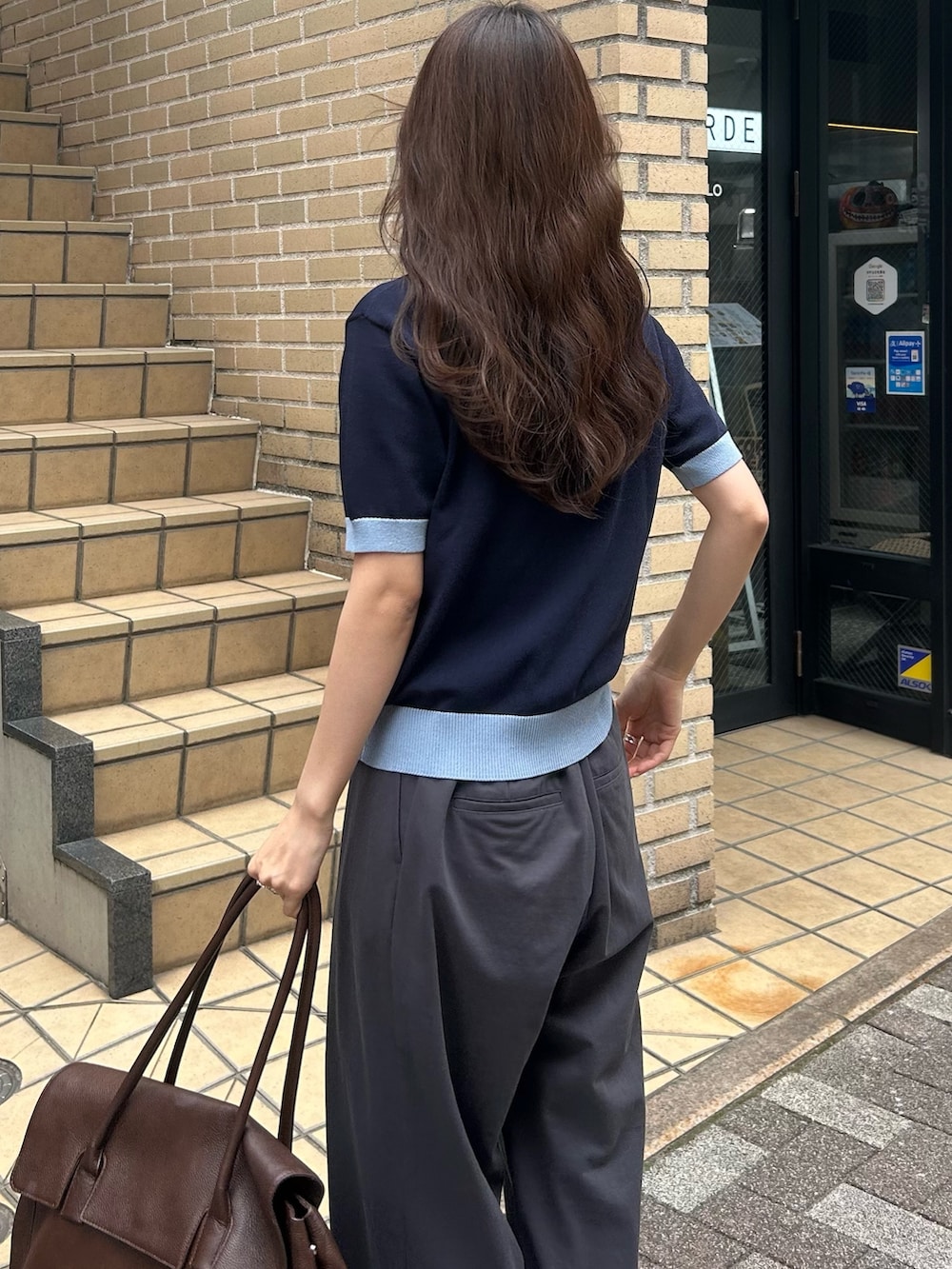 ブルー系のニット/セーター、グレー系のその他パンツ、ブラウン系のショルダーバッグを着用したレディースの春コーディネートの4枚目の写真